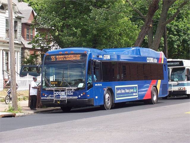 Bus pulling up to bus stop and loading passengers